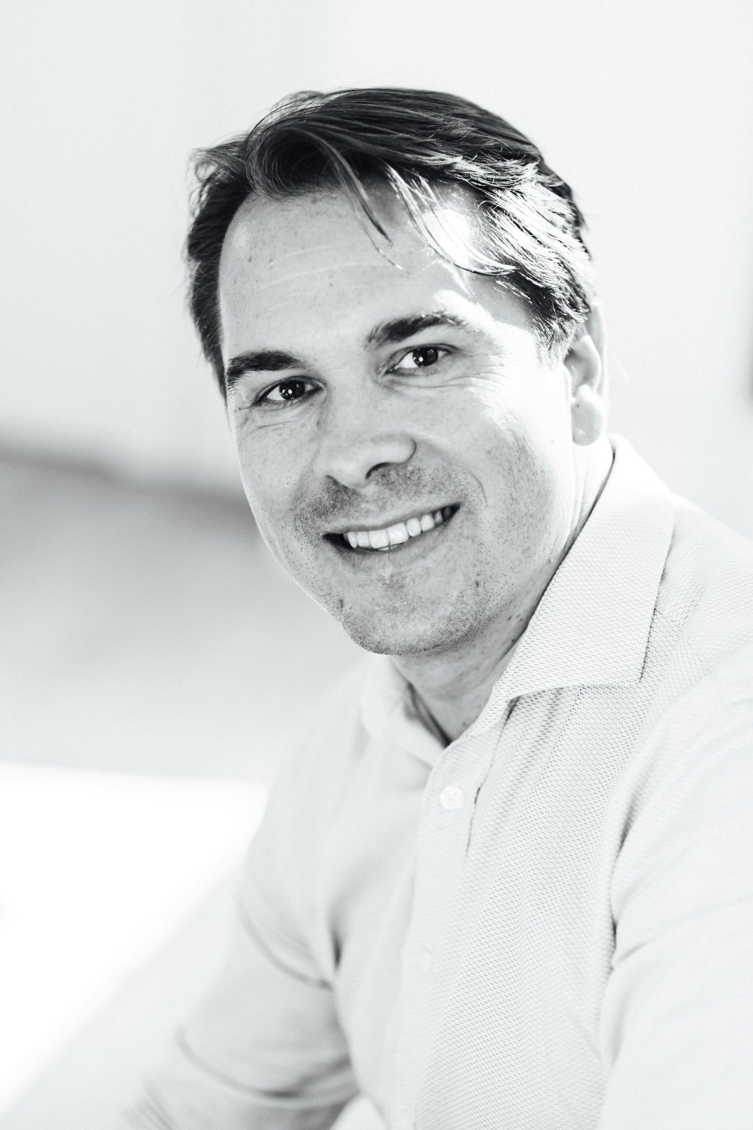 Consulter un hypnothérapeute à Boulogne-Billancourt : pourquoi ? Portrait en noir et blanc de Mathieu Boileau, hypnothérapeute à Boulogne-Billancourt, souriant en polo clair